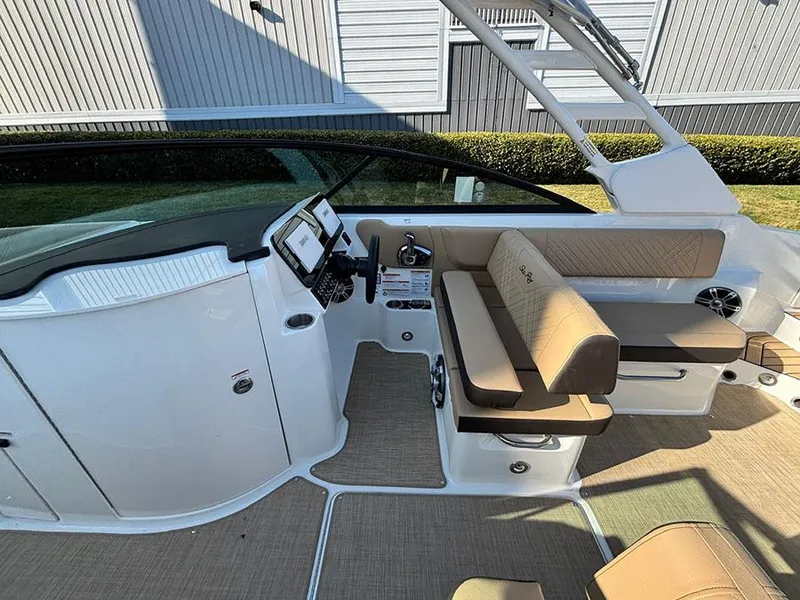 Slide: The Image of 2025 Sea Ray SDX 270 Outboard interior with beige seating and modern dashboard. - 11