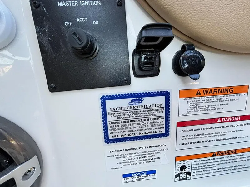 Slide: The Image of 2025 Sea Ray SDX 270 Outboard dashboard with ignition, certification, and warning labels. - 14