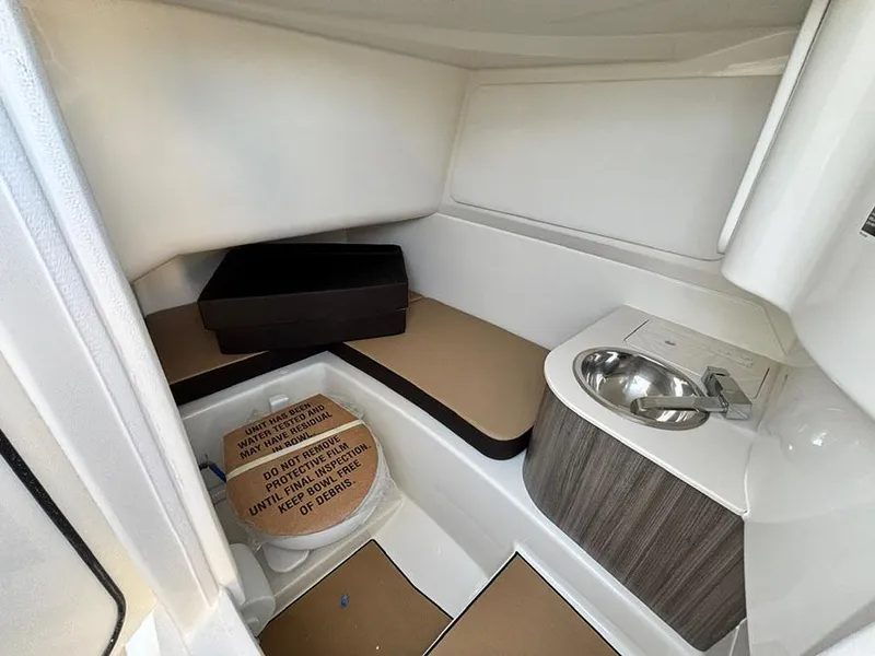 Slide: The Image of 2025 Sea Ray SDX 270 Outboard interior cabin with sink and seating area. - 16