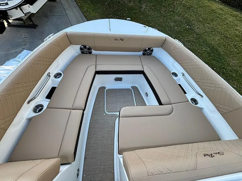 Slide: The Image of 2025 Sea Ray SDX 270 Outboard boat interior with beige seating and cup holders. - 19
