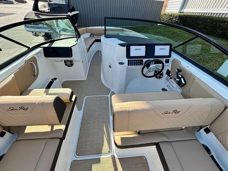 Slide: The Image of 2025 Sea Ray SDX 270 Outboard boat interior with beige seating and modern dashboard. - 9