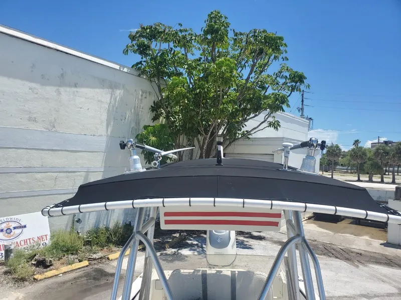 Slide: The Image of 2003 Hydra-Sports 2400 CC Vector boat with T-top, parked near a building and tree. - 15