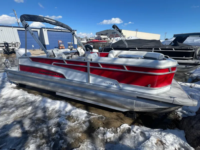 The Image of 2025 Princecraft Vectra 23 RL pontoon boat with red and silver design, parked on snowy ground. - 0
