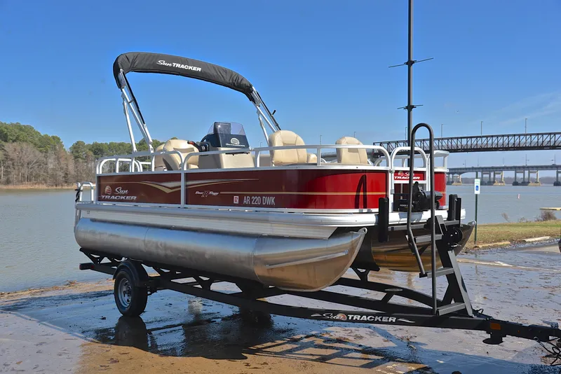 Slide: The Image of 2022 Sun Tracker BASS BUGGY 18 pontoon boat on trailer by a lake. - 16
