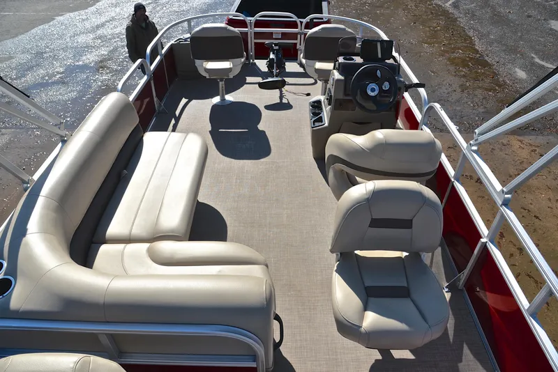 Slide: The Image of 2022 Sun Tracker BASS BUGGY 18 pontoon boat interior with beige seating and steering console. - 18