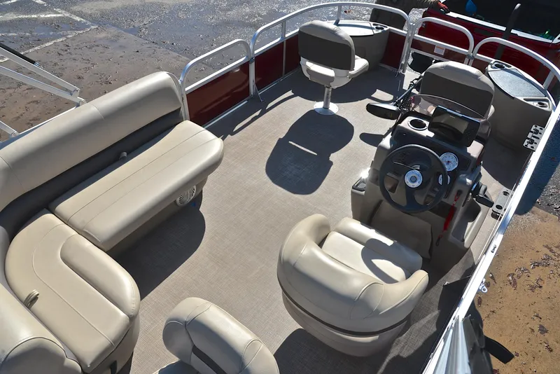 Slide: The Image of 2022 Sun Tracker BASS BUGGY 18 pontoon boat interior with beige seating and steering console. - 19