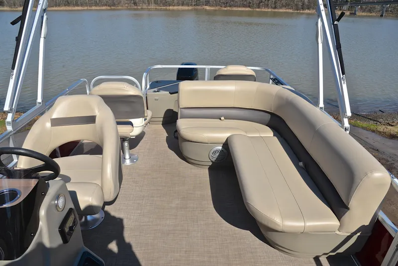 Slide: The Image of 2022 Sun Tracker BASS BUGGY 18 pontoon boat interior with beige seating on a lake. - 24