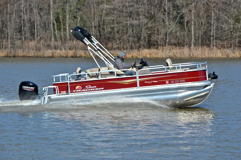 Slide: The Image of 2022 Sun Tracker BASS BUGGY 18 pontoon boat cruising on a lake. - 3