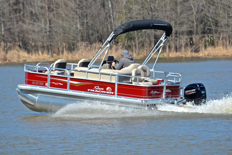 Slide: The Image of 2022 Sun Tracker BASS BUGGY 18 pontoon boat cruising on a lake. - 4
