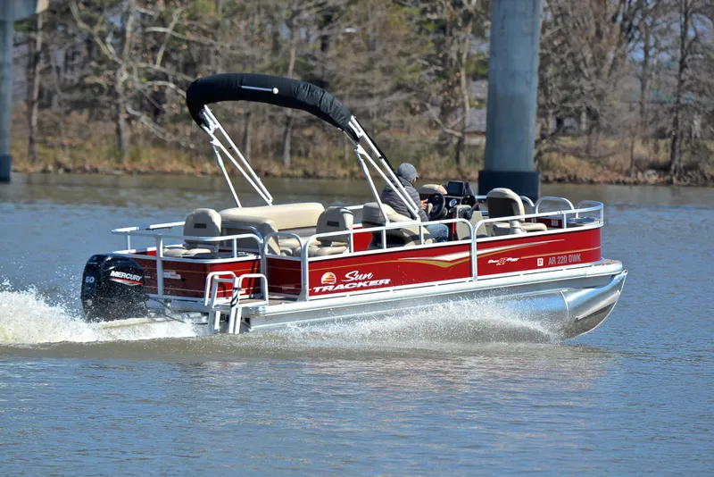 Slide: The Image of 2022 Sun Tracker BASS BUGGY 18 pontoon boat cruising on a lake. - 5