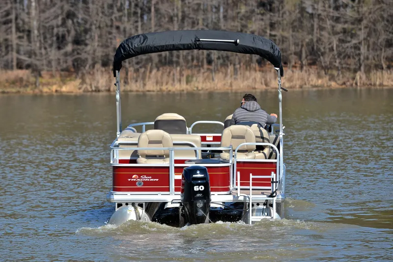 Slide: The Image of 2022 Sun Tracker BASS BUGGY 18 pontoon boat on a lake, rear view. - 7