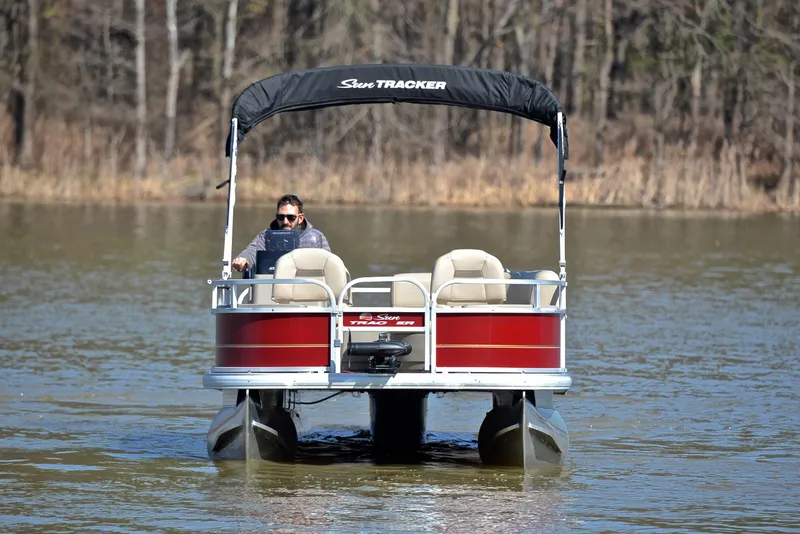 Slide: The Image of 2022 Sun Tracker BASS BUGGY 18 pontoon boat on a lake, with canopy and driver. - 9