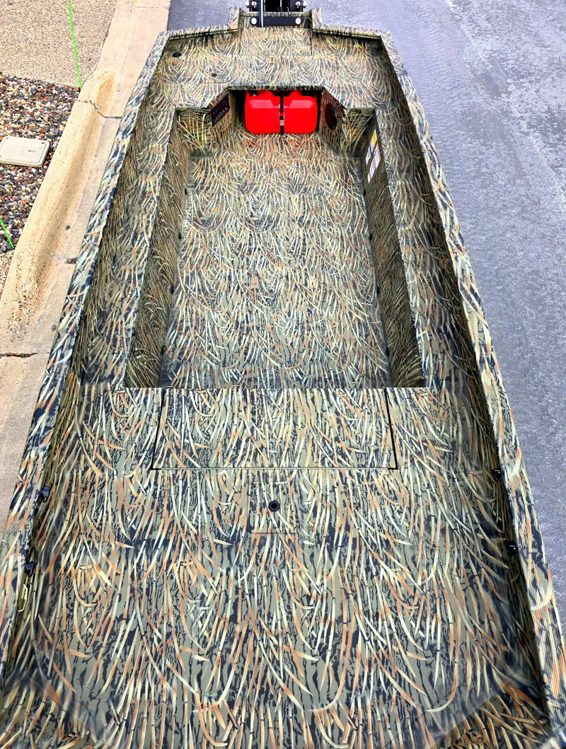 Slide: The Image of 2025 Tracker Grizzly 1650 T Prairie Wings Edition boat with camouflage design and red fuel tank. - 2