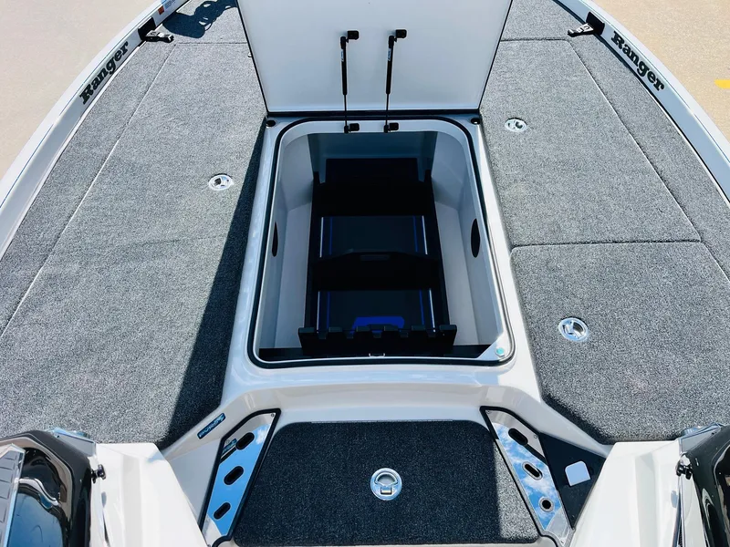 Slide: The Image of 2025 Ranger Z521R Cup-Equipped boat with open storage compartment, gray carpeted deck. - 22