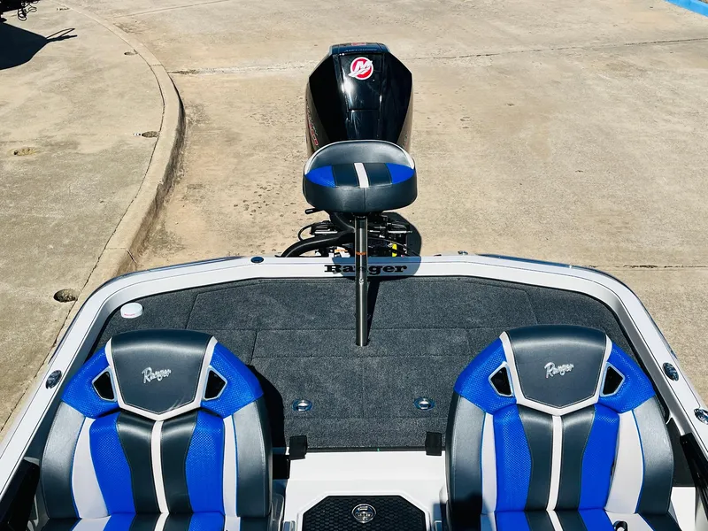 Slide: The Image of 2025 Ranger Z521R Cup-Equipped boat with blue seats and motor, parked on concrete. - 47