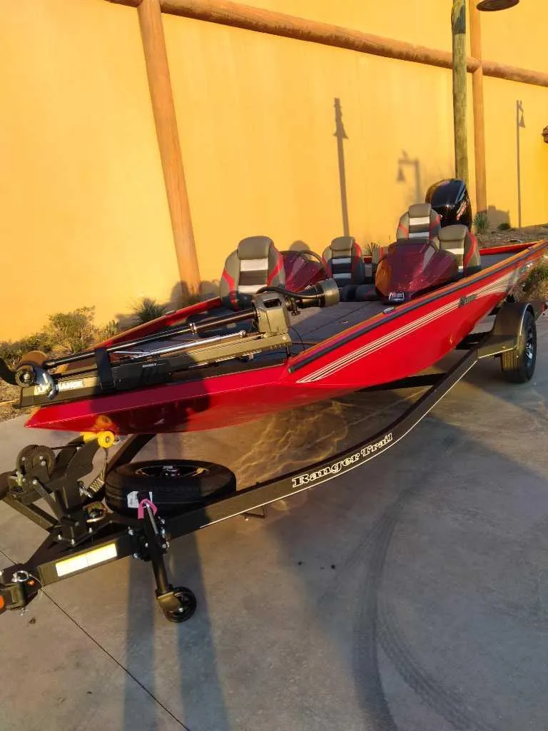 Slide: The Image of 2025 Ranger RT188P boat, red color, parked on concrete, side view. - 2