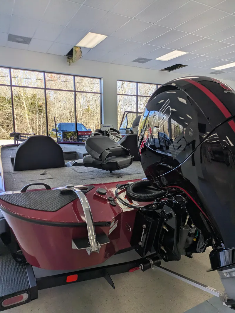 Slide: The Image of 2025 Tracker Savage 215 boat with spacious deck and seating in showroom. - 4