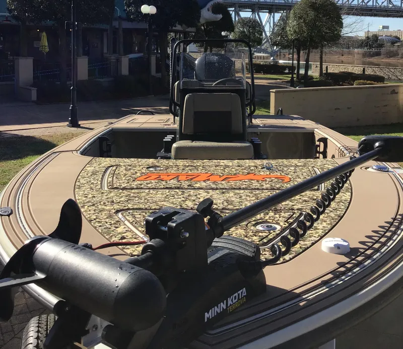 Slide: The Image of 2025 Mako 18 Pro Skiff Backwater Edition with Minn Kota motor, parked outdoors. - 2