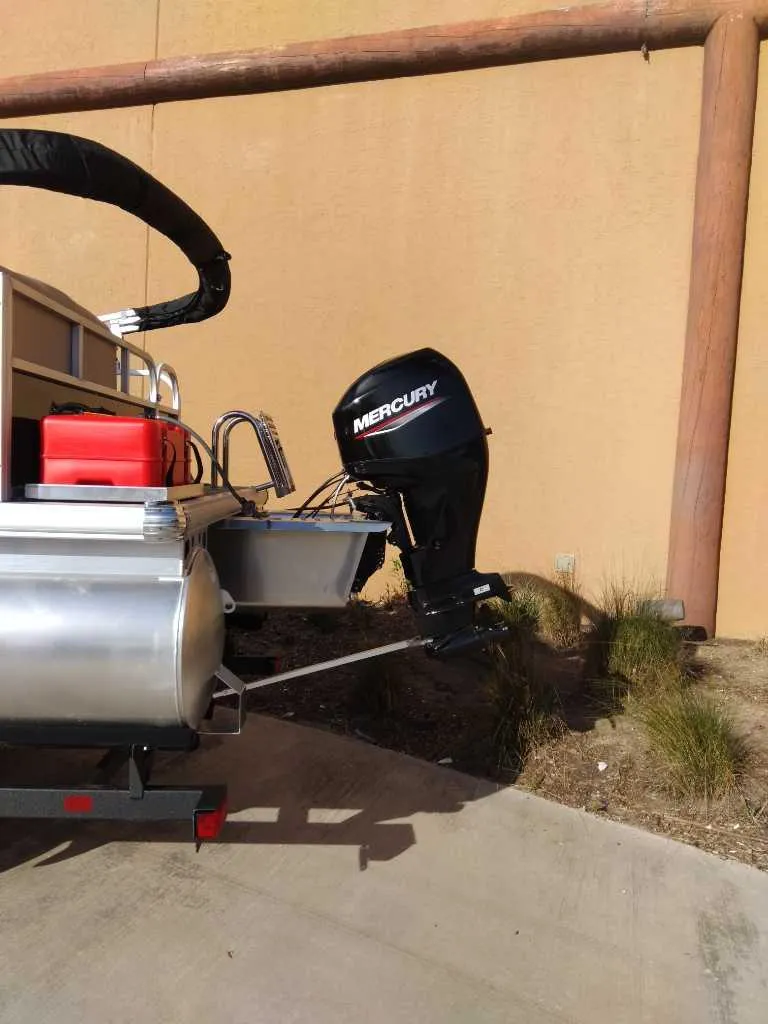 Slide: The Image of 2025 Sun Tracker Party Barge 16 DLX with Mercury outboard motor, parked outdoors. - 57