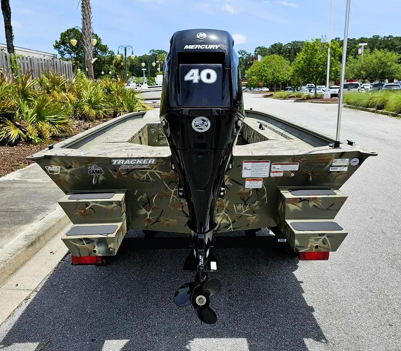 Slide: The Image of 2025 Tracker Grizzly 1654 T Sportsman boat with Mercury 40 engine, parked outdoors. - 3