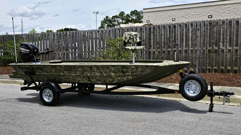 Slide: The Image of 2025 Tracker Grizzly 1654 T Sportsman boat on trailer, parked outdoors. - 5