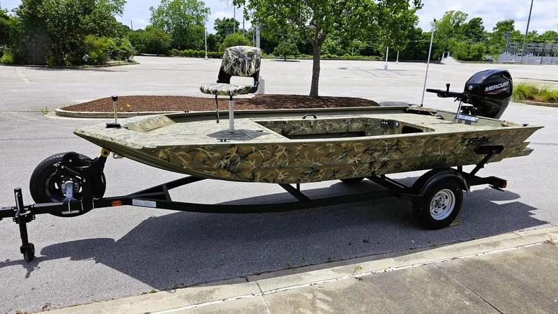 Slide: The Image of 2025 Tracker Grizzly 1654 T Sportsman boat on trailer in parking lot. - 8