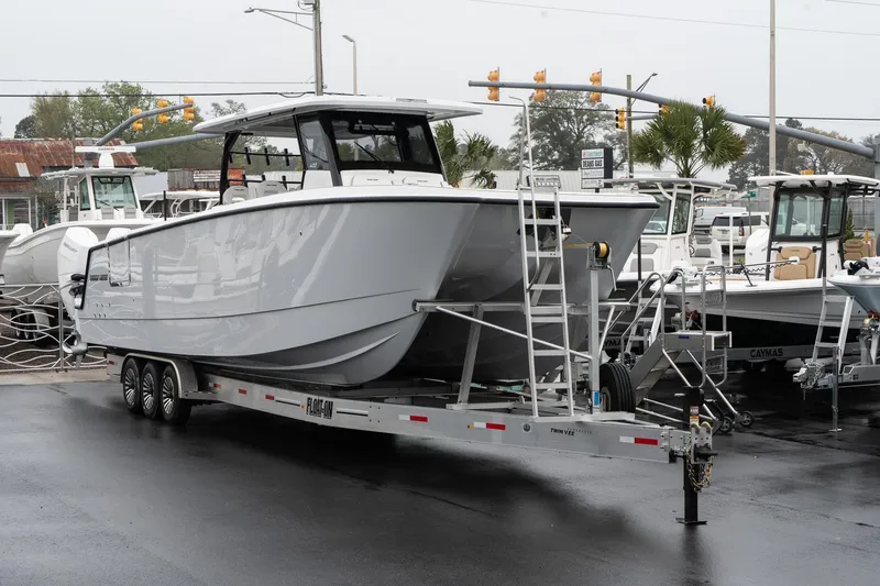 Slide: The Image of 2025 Twin Vee 400 GFX CC boat on trailer, displayed outdoors. - 2