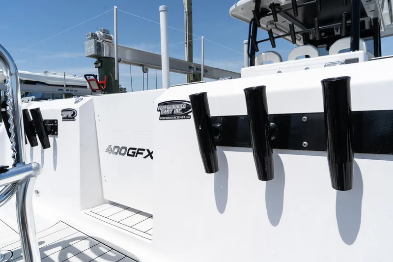 Slide: The Image of 2025 Twin Vee 400 GFX CC boat with rod holders, sleek white design. - 20