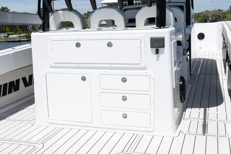 Slide: The Image of 2025 Twin Vee 400 GFX CC boat interior with white storage compartments and seating. - 22