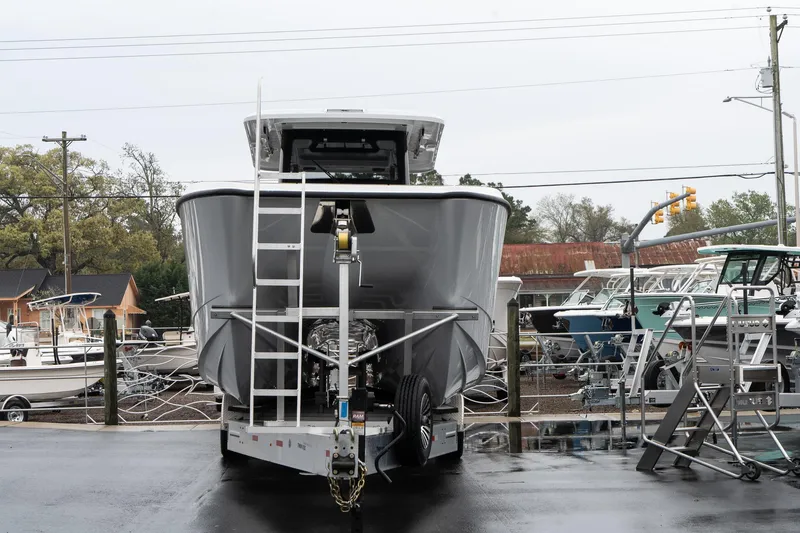 Slide: The Image of 2025 Twin Vee 400 GFX CC boat on trailer, front view, in a marina setting. - 3