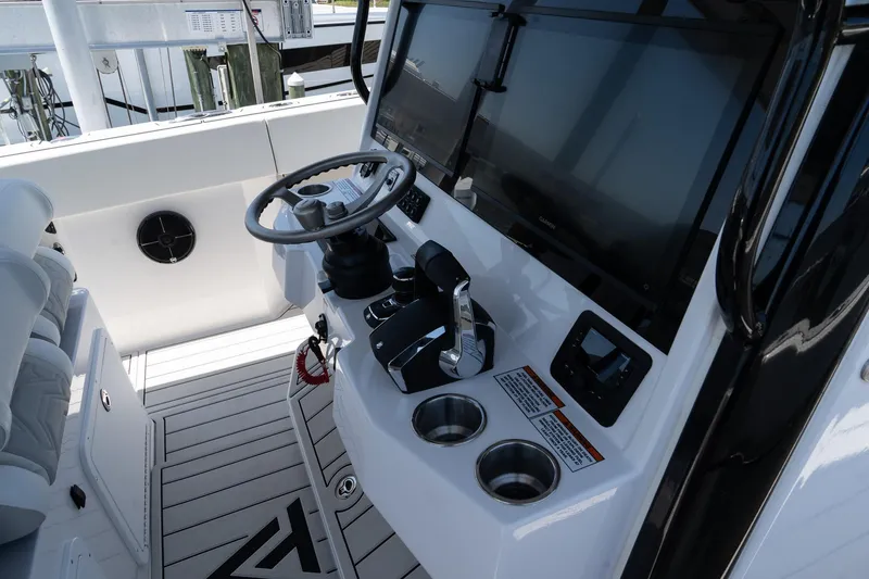 Slide: The Image of 2025 Twin Vee 400 GFX CC boat cockpit with steering wheel and controls. - 32