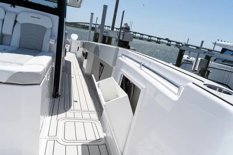Slide: The Image of 2025 Twin Vee 400 GFX CC boat deck with seating, docked by the water. - 40