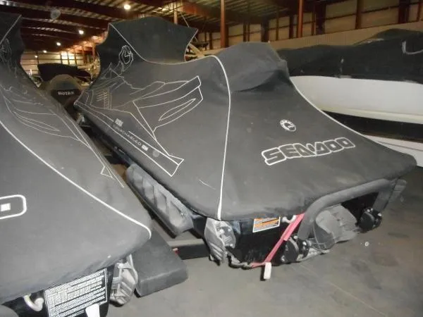 Slide: The Image of 2007 Sea-Doo RXT 215 jet skis covered in storage, indoor warehouse setting. - 4