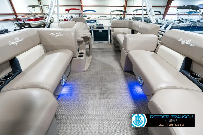 Slide: The Image of 2024 SunChaser 16 Vista pontoon boat interior with beige seating and blue LED lighting. - 16