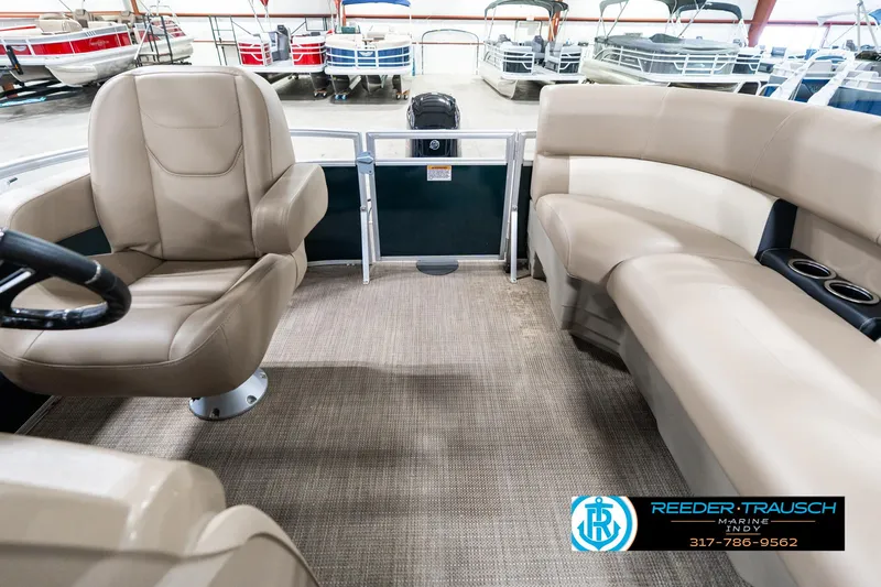 Slide: The Image of 2024 SunChaser 16 Vista pontoon boat interior with beige seating and carpet flooring. - 17