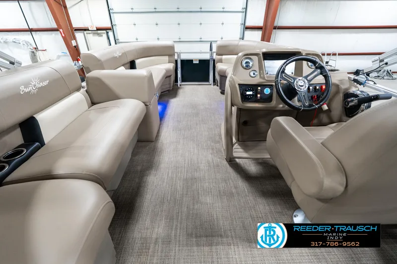 Slide: The Image of 2024 SunChaser 16 Vista pontoon boat interior with beige seating and modern dashboard. - 19