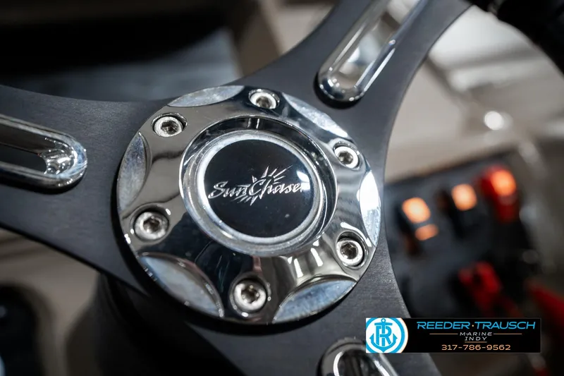Slide: The Image of Steering wheel of 2024 SunChaser 16 Vista boat with logo and controls. - 28
