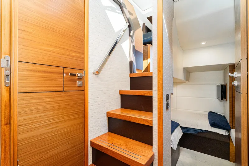 Slide: The Image of Interior of 2017 Tiara Yachts 44 Coupe, featuring wooden stairs and cozy cabin space. - 15