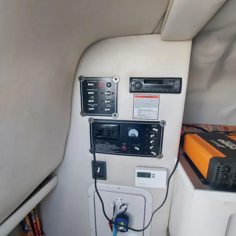 Slide: The Image of Control panel inside a 2000 Crownline 242 CR boat cabin, featuring various electronic devices. - 11