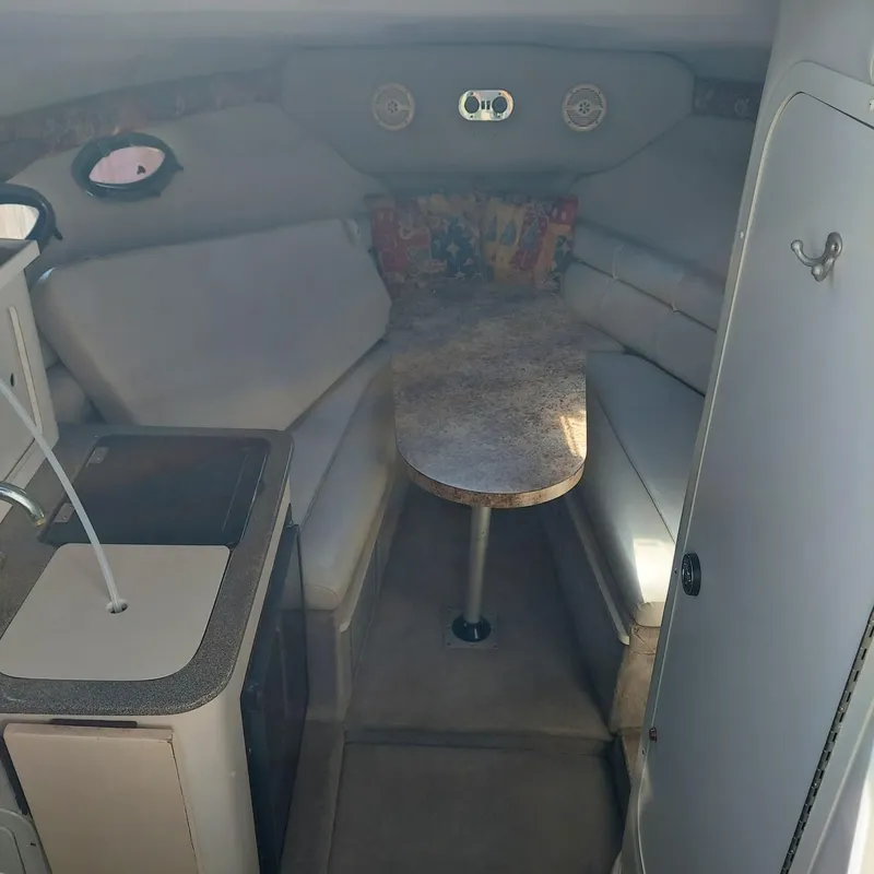 Slide: The Image of Interior of 2000 Crownline 242 CR boat with seating and table. - 17