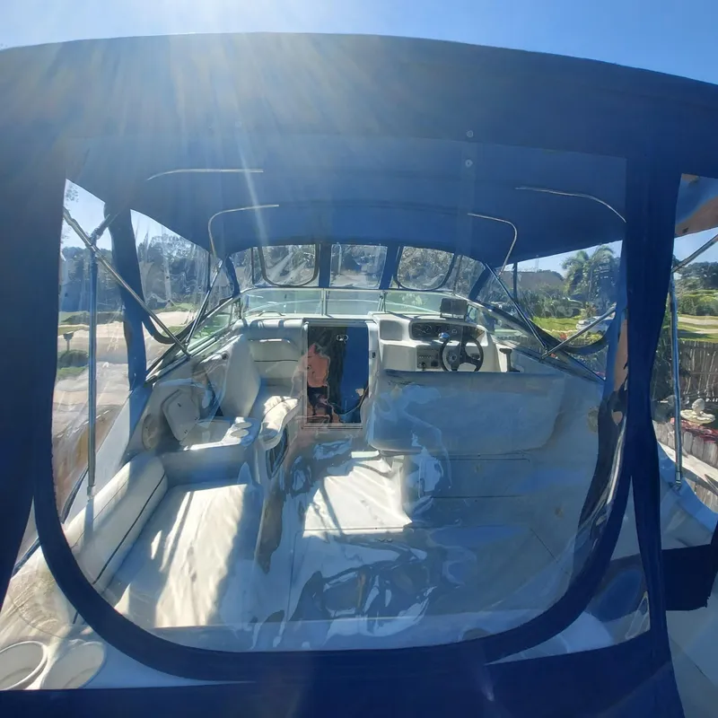 Slide: The Image of 2000 Crownline 242 CR boat interior with blue canopy and seating area. - 31