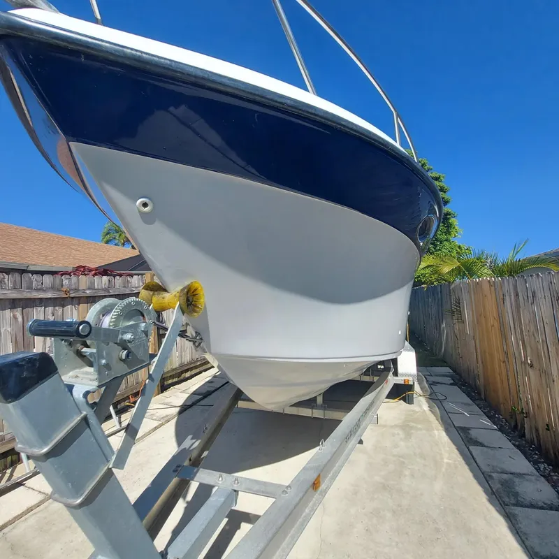 Slide: The Image of 2000 Crownline 242 CR boat on trailer, blue and white hull, sunny day. - 47