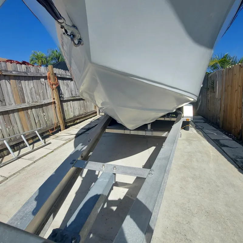 Slide: The Image of Crownline 242 CR boat on trailer, 2000 model, parked in a sunny driveway. - 49
