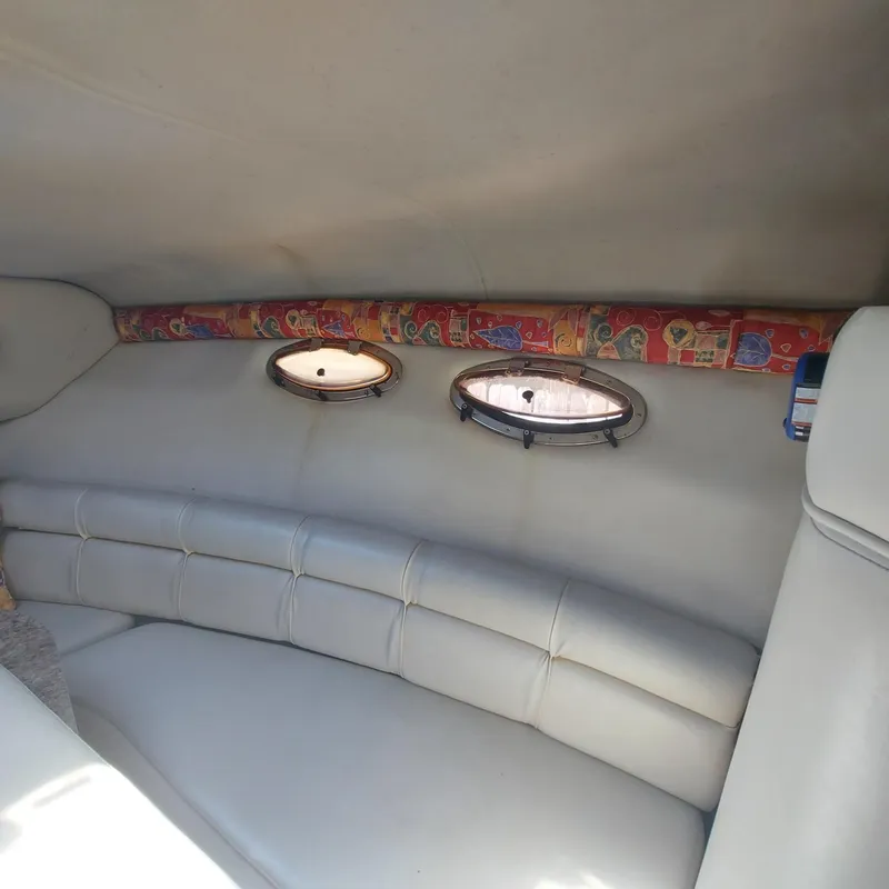 Slide: The Image of Interior of 2000 Crownline 242 CR boat with white seating and porthole windows. - 6