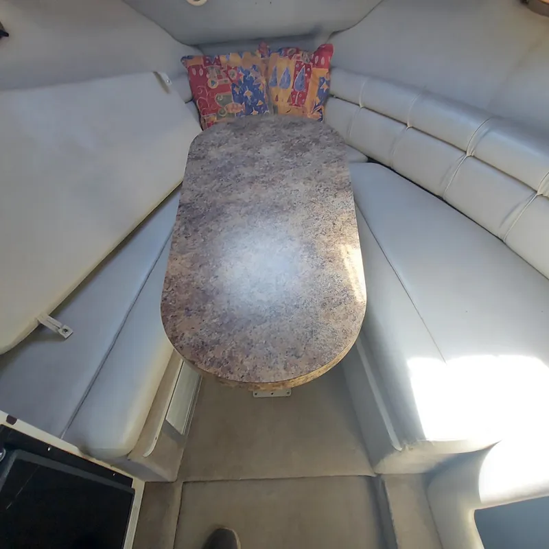 Slide: The Image of Interior of 2000 Crownline 242 CR boat with table and seating area. - 7