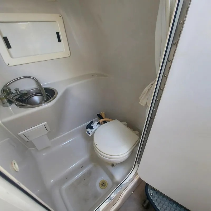 Slide: The Image of Compact bathroom in 2000 Crownline 242 CR boat with sink and toilet. - 8