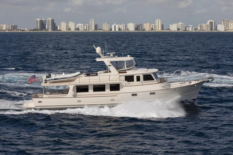 Slide: The Image of Luxury Fleming 78 yacht cruising on ocean with city skyline in background, 2027 model. - 5