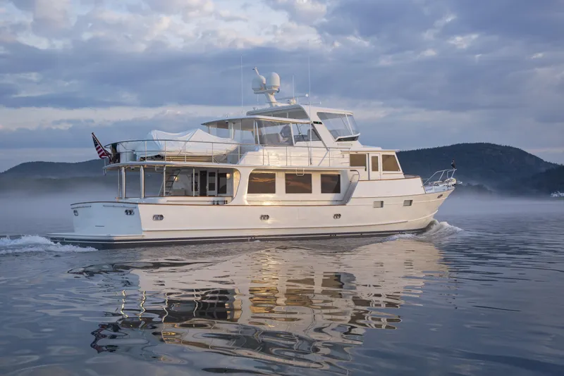 Slide: The Image of Luxury Fleming 78 yacht cruising on calm waters, 2027 model, under a cloudy sky. - 7