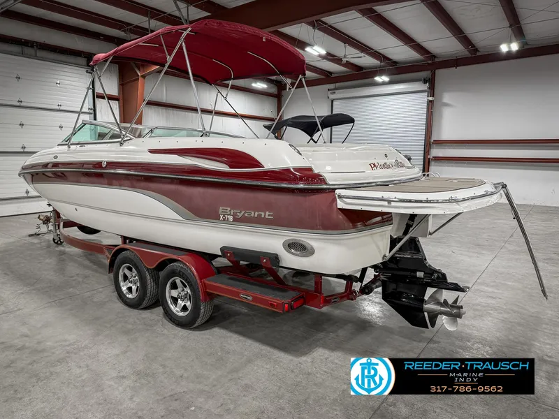 Slide: The Image of 2007 Bryant 240 boat with red and white design on a trailer in a warehouse. - 10