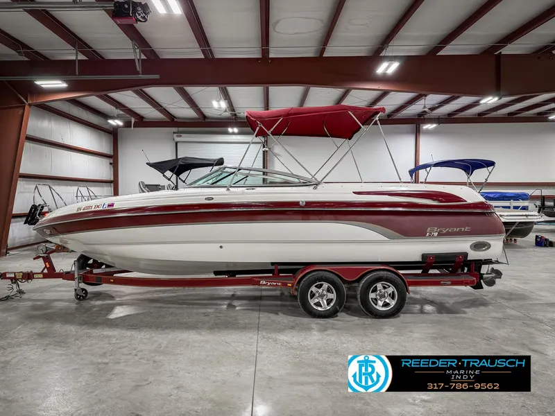Slide: The Image of 2007 Bryant 240 boat with red accents in a showroom, on a trailer. - 11